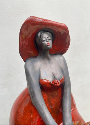 Keramisch Beeld ‘Proud of Her’ – Zittende Vrouw in Rood met Tulpen – Inclusief Houten Sokkeltje